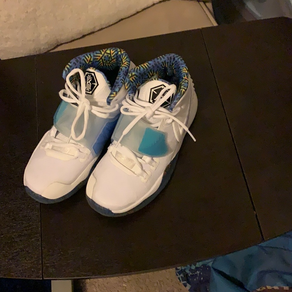 White and blue big boy Nike shoes.